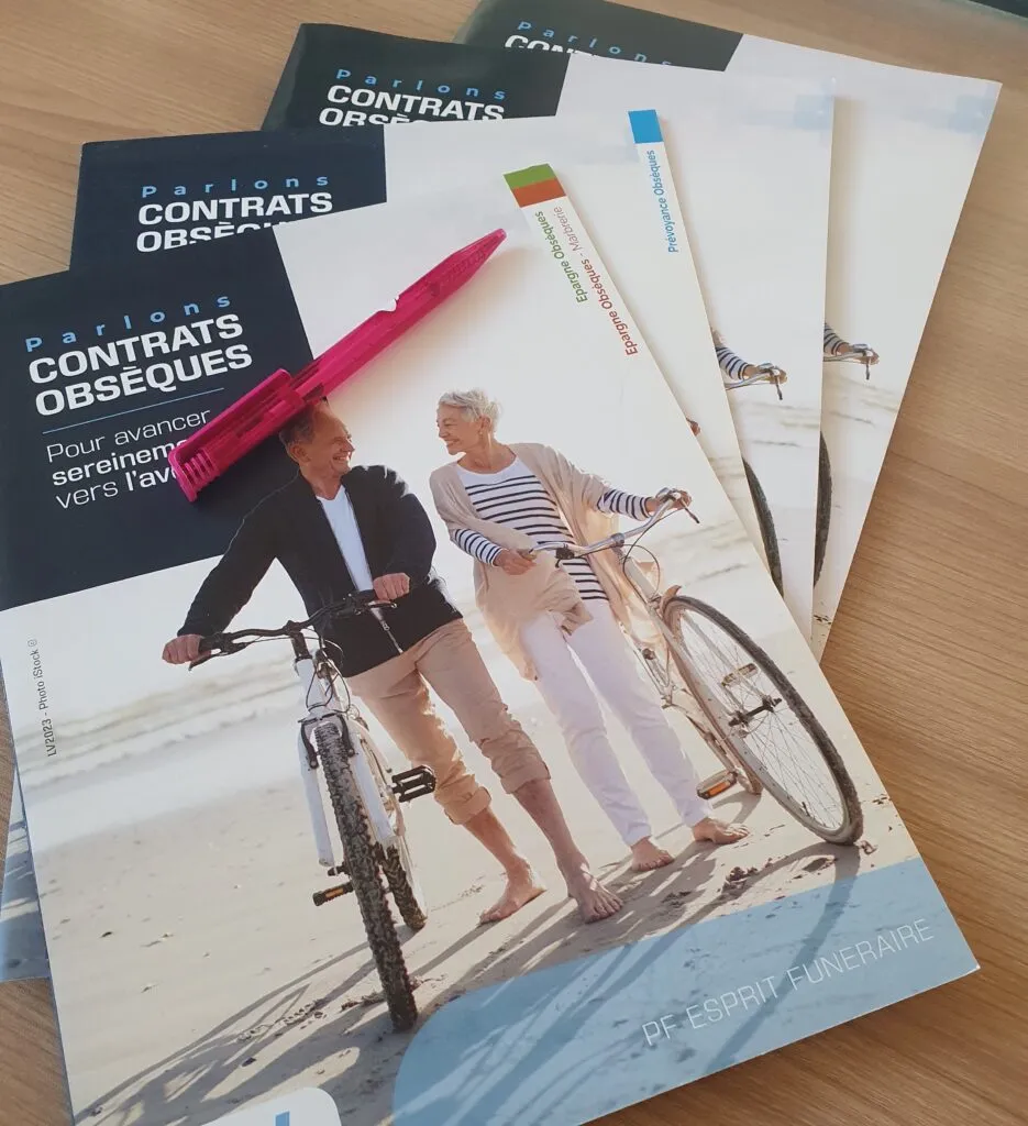 Brochures d'information sur les contrats obsèques et la prévoyance funéraire avec un stylo rose