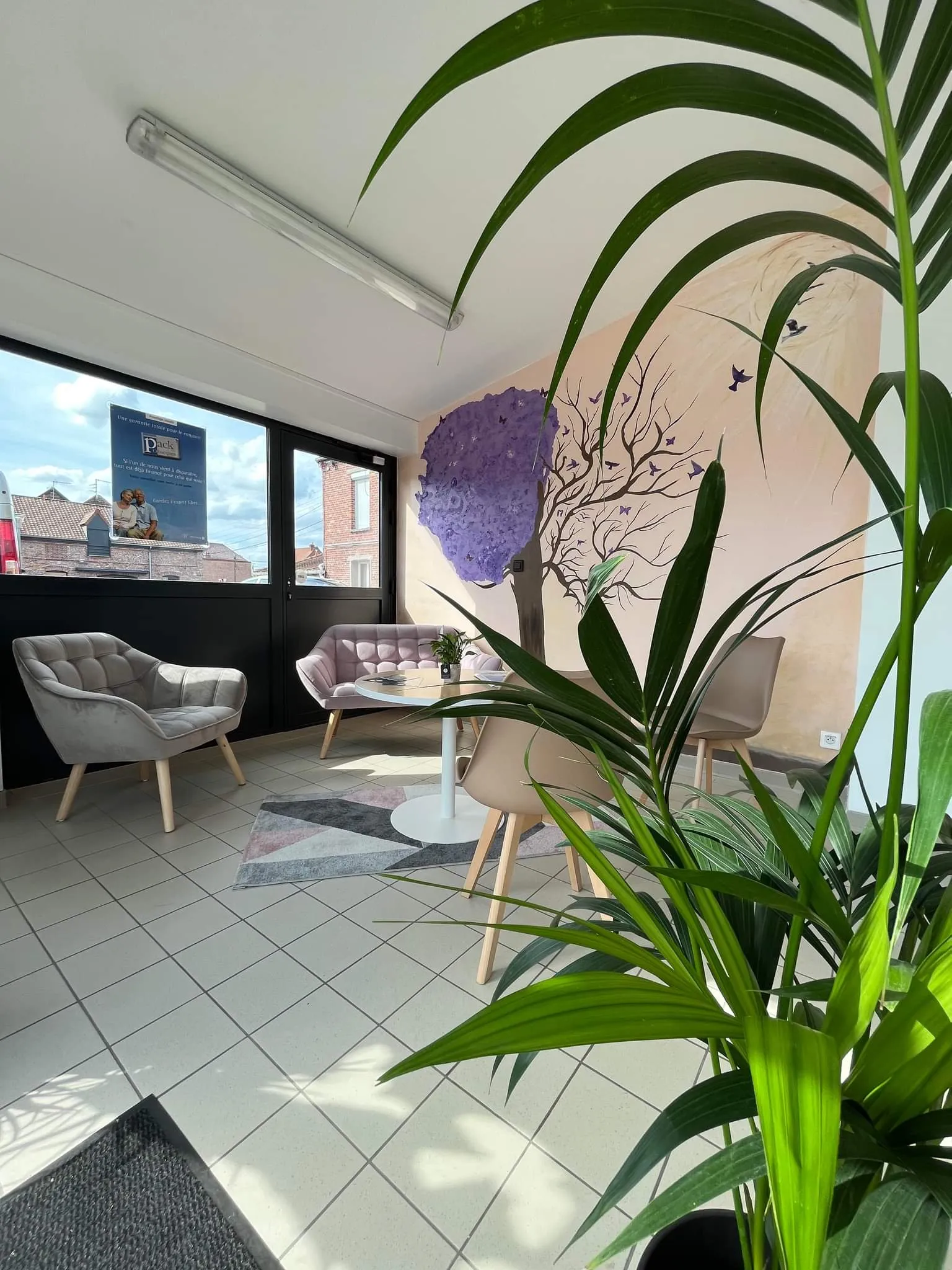 Espace d'attente confortable et décoré d'une fresque murale dans une agence funéraire
