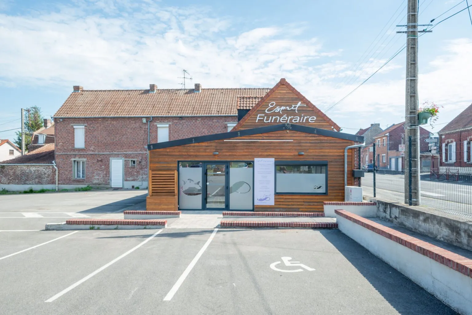 Façade en bois de l'agence Esprit Funéraire et son parking visiteurs